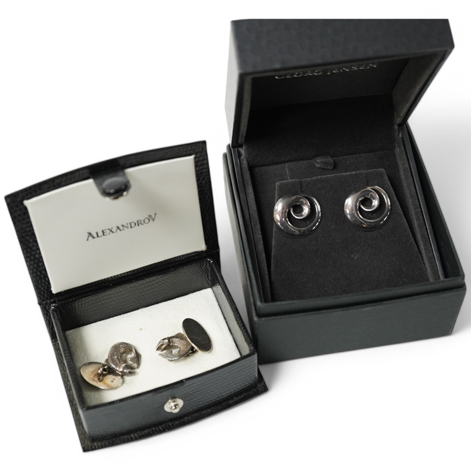 A modern pair of Georg Jensen 925S cufflinks, of swirling form, design no. 443, with original Georg Jensen box, 20mm, together with a modern pair of silver fish cufflinks by Sarah Jones, London, 1993/94. Condition fair a